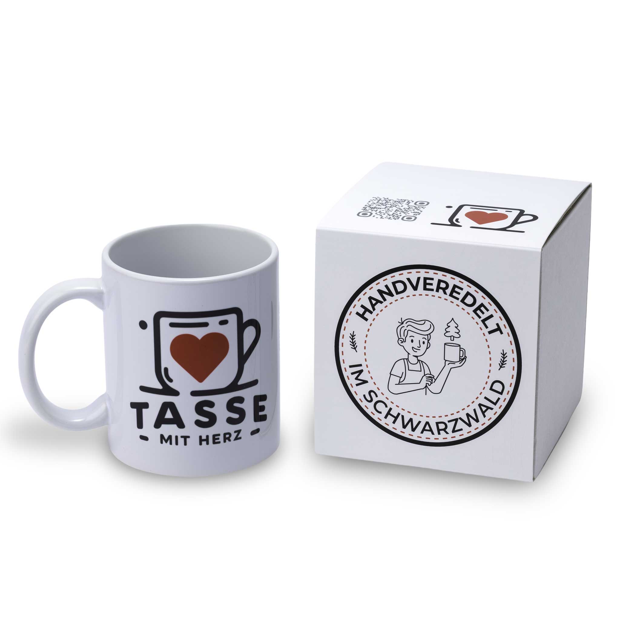 Personalisierte weiße Fototasse von Tasse mit Herz neben einem edlen weißen Geschenkkarton mit dem runden Siegel „Handveredelt im Schwarzwald“.